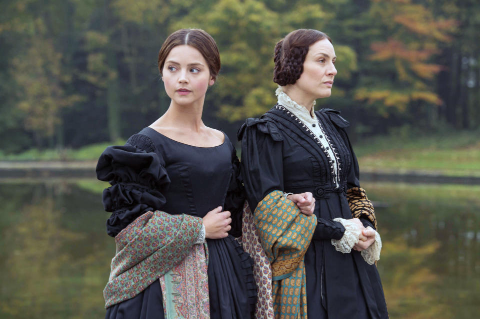 Jenna Coleman and Daniela Holtz stand outdoors arm in arm in period attire