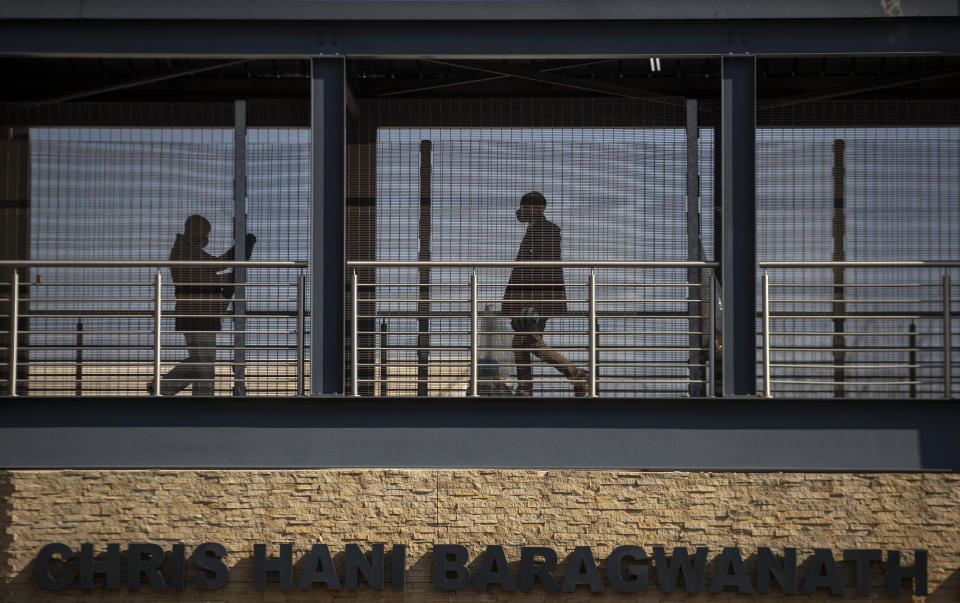 People walk along a skywalk to Chris Hani Bardgwanath Hospital in the township of Soweto in Johannesburg, South Africa, Saturday, July 18, 2020. (AP Photo/Themba Hadebe)