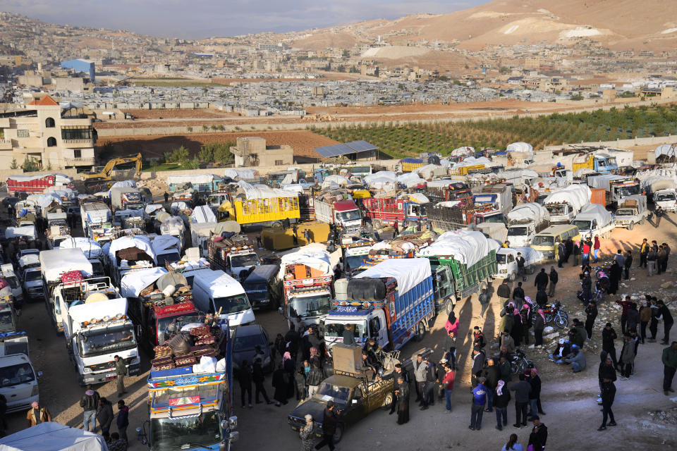 Syrian refugees gather near trucks, as they prepare to back home to Syria, in the eastern Lebanese border town of Arsal, Lebanon, Wednesday, Oct. 26, 2022. Several hundred Syrian refugees boarded a convoy of trucks laden with mattresses, water and fuel tanks, bicycles – and, in one case, a goat – Wednesday morning in the remote Lebanese mountain town of Arsal in preparation to return back across the nearby border.(AP Photo/Hussein Malla)