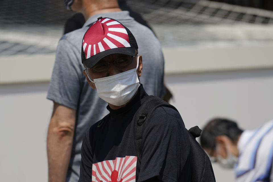 A worshipper queues to pay respects to the war dead at Yasukuni Shrine Saturday, Aug. 15, 2020, in Tokyo. Japan marked the 75th anniversary of the end of World War II. (AP Photo/Eugene Hoshiko)