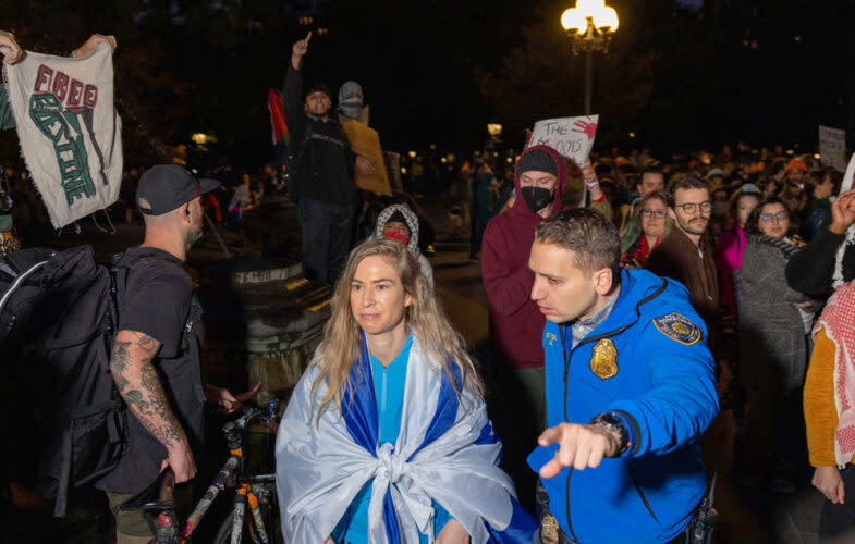 A pro-Israel counter protestor wrapped in the flag of Israel is escorted away from a vigil organized by New York University students in support of Palestinians in New York City on October 17. (Alex Kent/Getty Images)