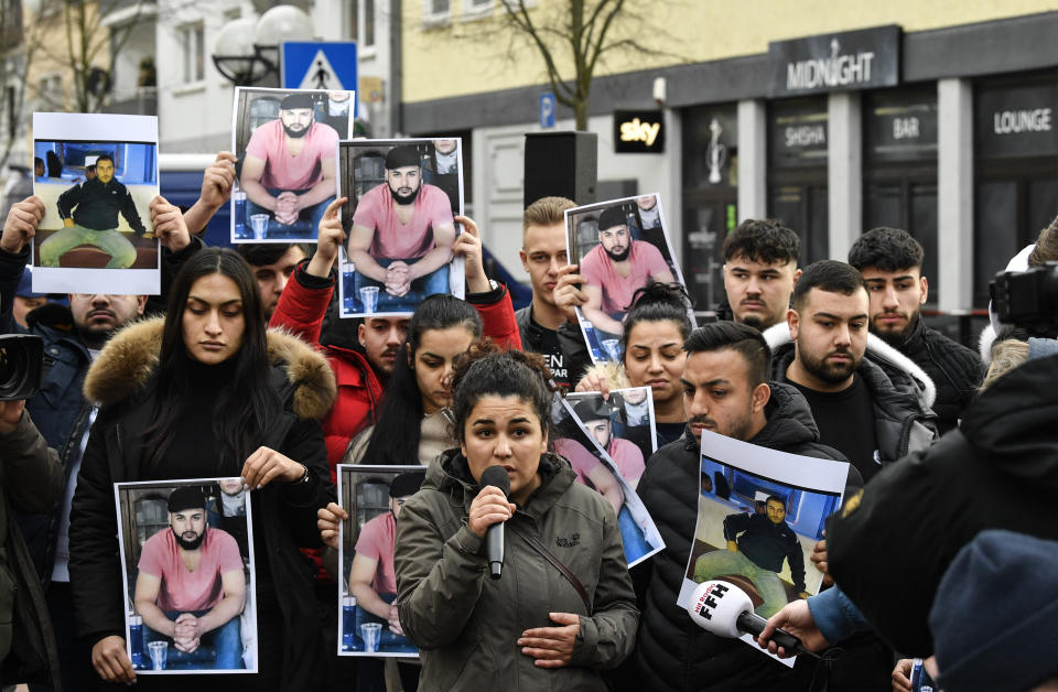 Friends and relatives hold up photos of victims of a shooting, in Hanau, Germany, on Friday, Feb. 21, 2020. A 43-year-old German man shot dead nine people of immigrant backgrounds in the Frankfurt suburb of Hanau on Wednesday night before killing his mother and himself. He left a number of rambling texts and videos espousing racist views. (AP Photo/Martin Meissner)