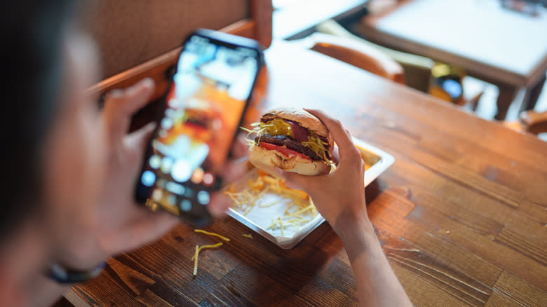 person taking a photo of their burger