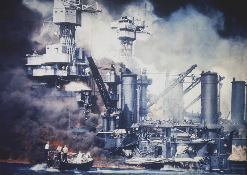 A small boat rescues a crew member of the battleship West Virginia from the water after the Japanese bombing of Pearl Harbor on Dec. 7, 1941. Skillful damage control saved the ship from capsizing, but she quickly sank to the harbor bottom. More than a hundred of her crew were lost. (AP Photo)