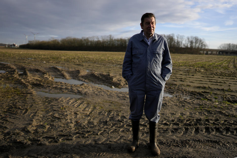 Bart Dochy stands in front of one of the fields at his family farm in Ledegem, Belgium, Tuesday, Feb. 13, 2024. After dealing with hectacres of fields and barns full of animals Dochy just as handily steps into a three-piece suit to pick up his job as mayor of this farming community in Landegem. (AP Photo/Virginia Mayo)