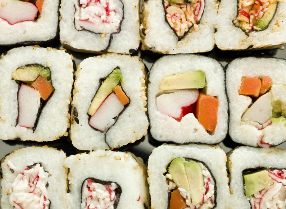 Close-up of assorted sushi rolls, featuring pieces with crab, avocado, and vegetables