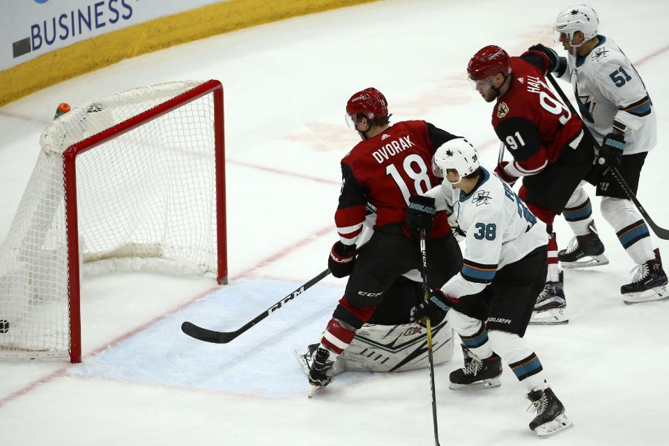 Arizona Coyotes left wing Taylor Hall (91) scores a goal as Coyotes center Christian Dvorak (18), San Jose Sharks defenseman Mario Ferraro (38) and Sharks defenseman Radim Simek (51) look on during the second period of an NHL hockey game Tuesday, Jan. 14, 2020, in Glendale, Ariz. (AP Photo/Ross D. Franklin)