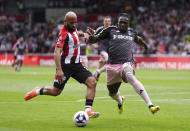 Brentford's Bryan Mbeumo, left, shoots under pressure from Fulham's Calvin Bassey during the English Premier League soccer match between Fulham FC and Brentford FC at the Gtech Community Stadium in London, Saturday May 4, 2024. (John Walton/PA via AP)