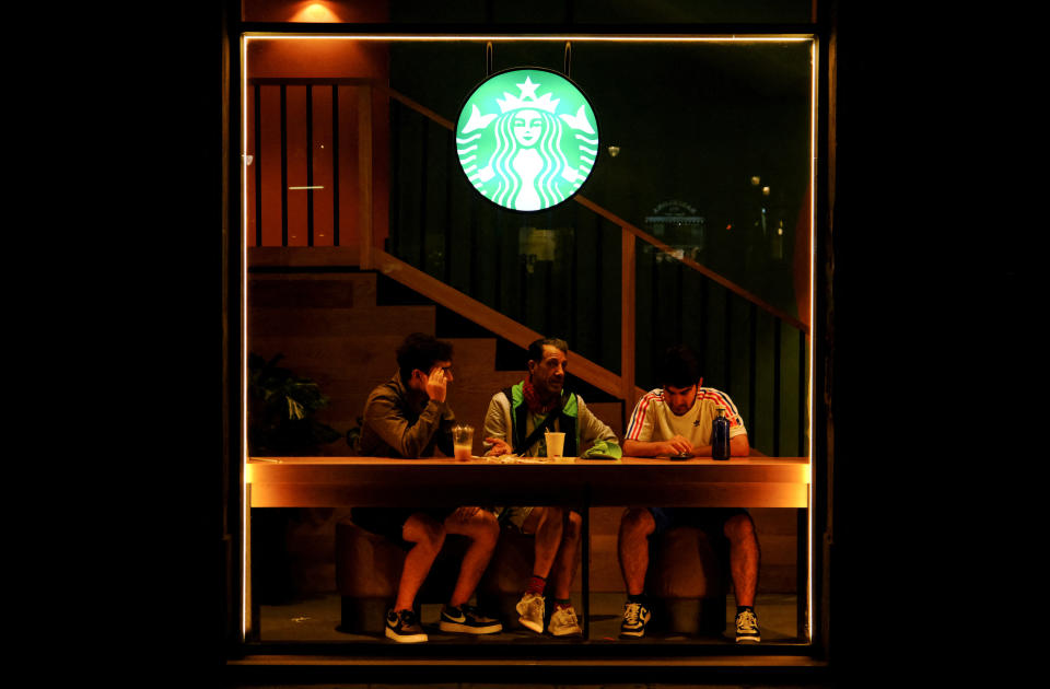 A Starbucks logo is seen as men sit at a Starbucks coffee shop in Barcelona, Spain, October 15, 2022. REUTERS/Nacho Doce