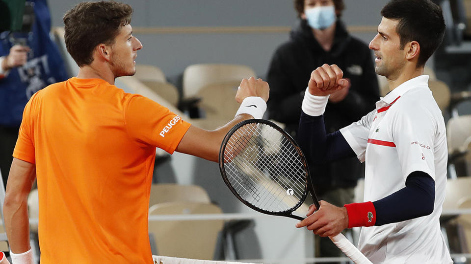 Novak Djokovic meets Pablo Carreno Busta at the net following victory in their Men's Singles quarterfinals match at the French Open. (Photo by Clive Brunskill/Getty Images)