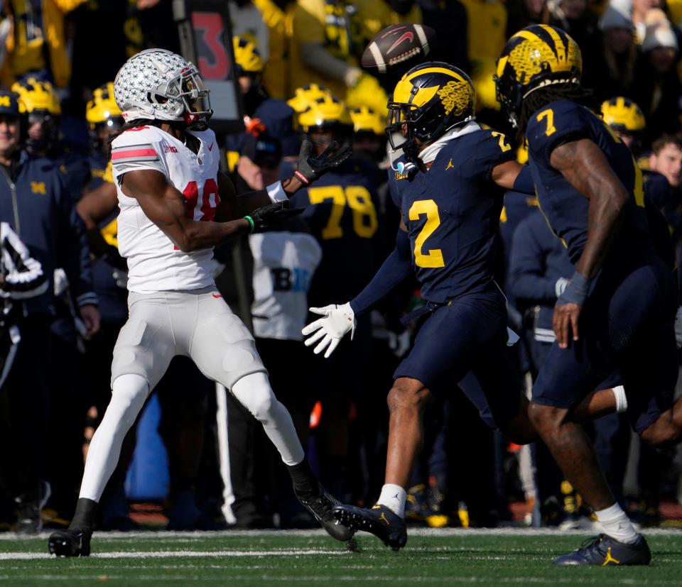 Nov. 25, 2023; Ann Arbor, Mi., USA;
Ohio State Buckeyes wide receiver Marvin Harrison Jr. (18) catches a pass while defended by Michigan Wolverines defensive back Will Johnson (2) and Michigan Wolverines defensive back Makari Paige (7) during the first half of Saturday's NCAA Division I football game at Michigan Stadium.