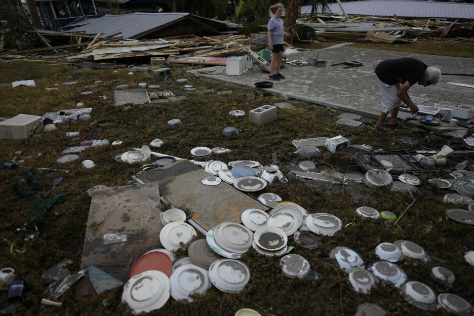 Tina Brotherton, 88, right, gets help 9-year-old neighbor Lainey Hamelink, as she surveys the wreckage of her business, Tina's Dockside Inn, which was completely destroyed in Hurricane Idalia, as was Brotherton's nearby home, in Horseshoe Beach, Fla., Friday, Sept. 1, 2023, two days after the storm's passage. A resident of Horseshoe Beach since 1978, she lost her marina and the cafe next door in a 1993 disaster and had to replace the floors and beds at Tina's Dockside Inn. Now the hotel, which she has owned for 52 years, is destroyed in Idalia's wake. (AP Photo/Rebecca Blackwell, File)