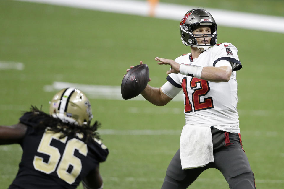 Tampa Bay Buccaneers quarterback Tom Brady (12) passes in front of New Orleans Saints outside linebacker Demario Davis (56) during the second half of an NFL divisional round playoff football game, Sunday, Jan. 17, 2021, in New Orleans. (AP Photo/Butch Dill)