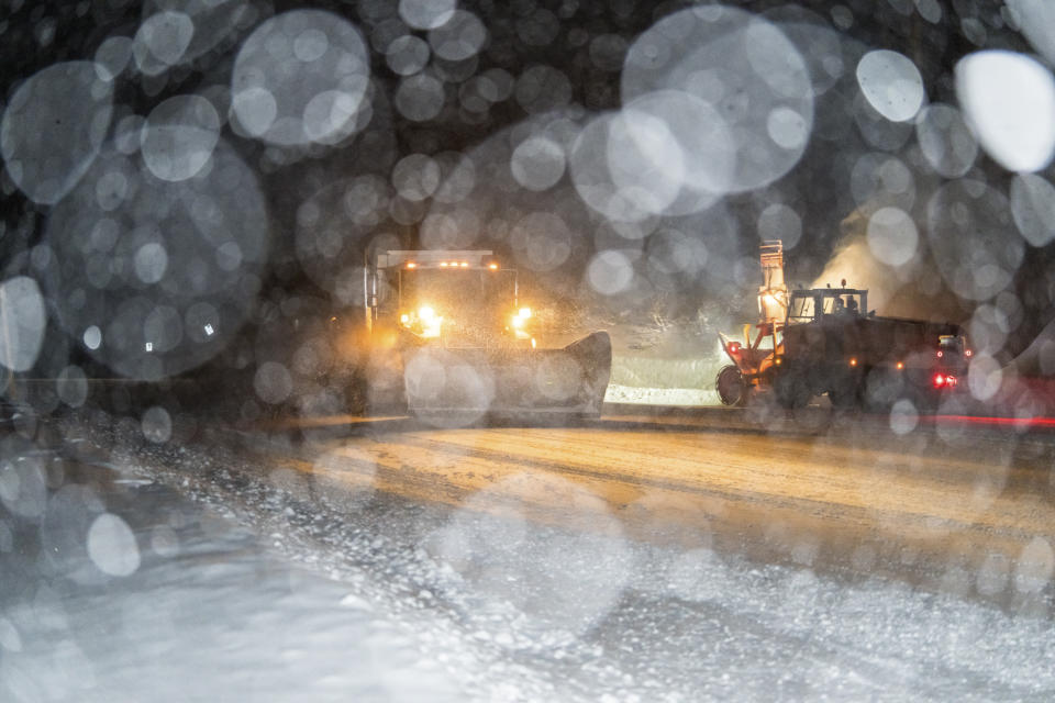 In this photo provided by the Mammoth Mountain Ski Area, plows make their way along a snow covered road during a storm in Mammoth Lakes, Calif., Monday, Jan. 22, 2024. (Christian Pondella/Mammoth Mountain Ski Area via AP)