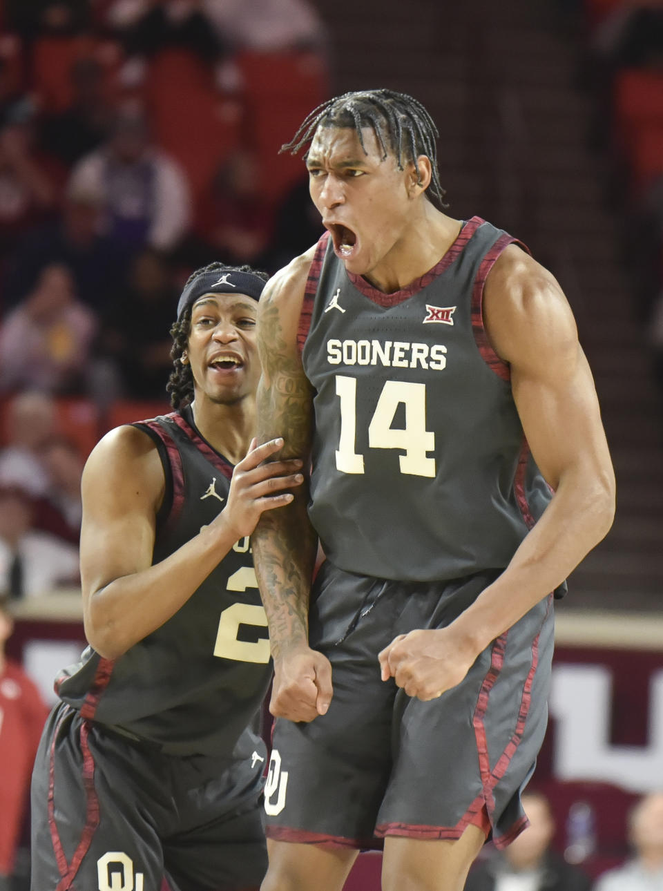 Oklahoma's Javian McCollum (2) and Jalon Moore (14) celebrate during the first half of the team's NCAA college basketball game against West Virginia, Wednesday, Jan. 17, 2024, in Norman, Okla. (AP Photo/Kyle Phillips)