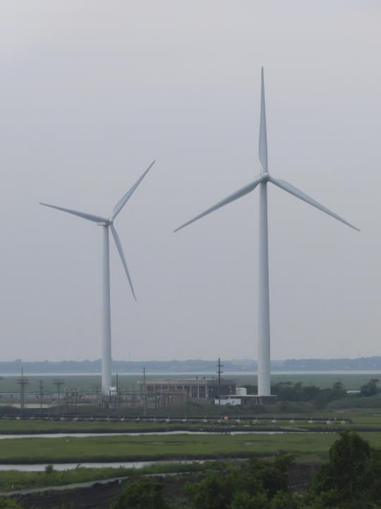 Land-based wind turbines turn in Atlantic City, N.J. on July 20, 2023. On Oct. 2, 2023, New York based Attentive Energy said it plans to build a wind energy farm 42 miles off the coast of Seaside Heights, N.J., the farthest offshore of the seven wind projects publicly proposed for New Jersey and among the farthest offshore on the U.S. East Coast. (AP Photo/Wayne Parry)