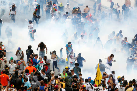 Demonstrators are seen amidst tear gas fired by police during an opposition rally in Caracas, Venezuela, April 6, 2017. REUTERS/Christian Veron