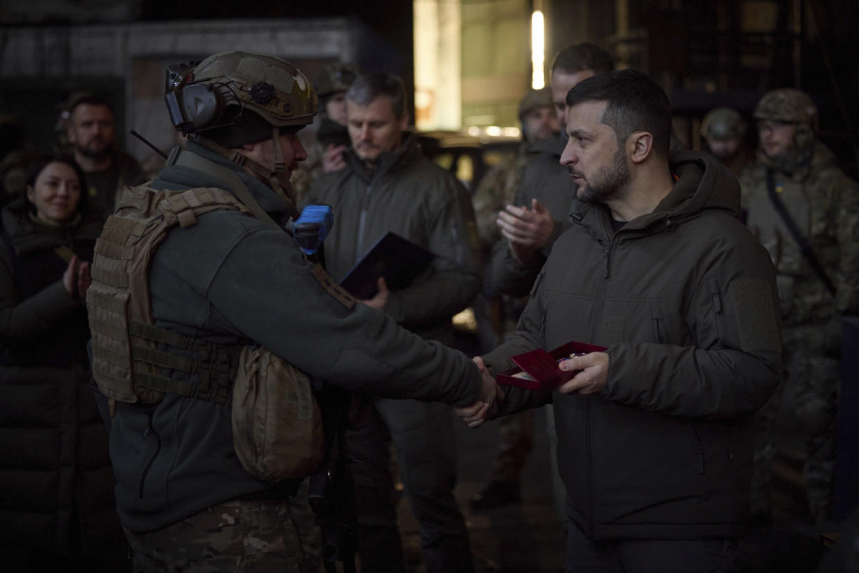 In this photo provided by the Ukrainian Presidential Press Office, Ukrainian President Volodymyr Zelenskyy, right, awards a serviceman at the site of the heaviest battles with the Russian invaders in Bakhmut, Ukraine, Tuesday, Dec. 20, 2022. (Ukrainian Presidential Press Office via AP)