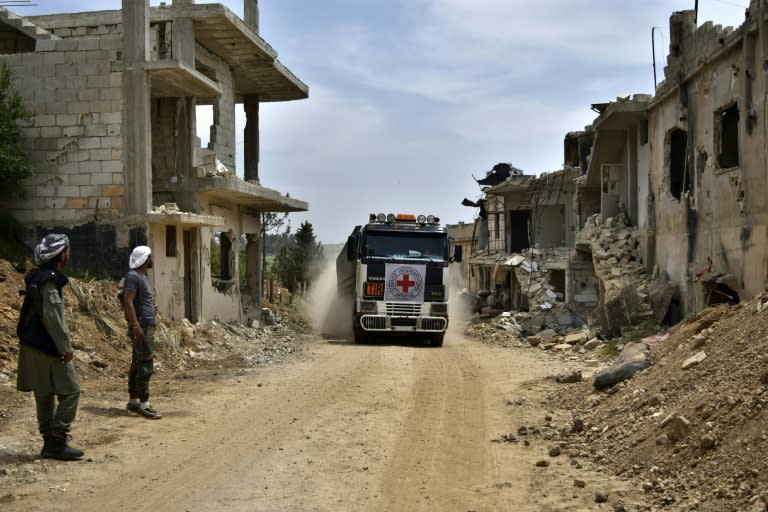 An aid truck of the International Committee of the Red Cross (ICRC) drives past destroyed buildings in the rebel-held village of Teir Maalah, on its way to Talbisseh, on the northern outskirts of Homs in central Syria, on May 2, 2016