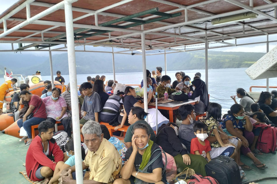 In this photo provided by the Indonesian National Search and Rescue Agency (BASARNAS), residents of Tagulandang island sit on a ship of National Search and Rescue Agency to evacuate after Mount Ruang releases volcanic materials in Sulawesi island, Indonesia, Wednesday, May 1, 2024. Indonesia's Mount Ruang volcano erupted Tuesday for a second time in two weeks, spewing ash almost 2 kilometers (more than a mile) into the sky, closing an airport and peppering nearby villages with debris.(Indonesian National Search and Rescue Agency via AP)