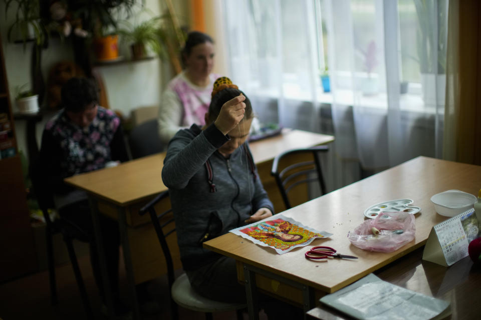 Residents sew their artwork in a classroom at a public institution for people with mental and physical disabilities in the village of Tavriiske, Ukraine, Tuesday, May 10, 2022. With around 425 residents, the institution is the largest such facility for people with disabilities in southeastern Ukraine's Zaporizhzhia region. (AP Photo/Francisco Seco)