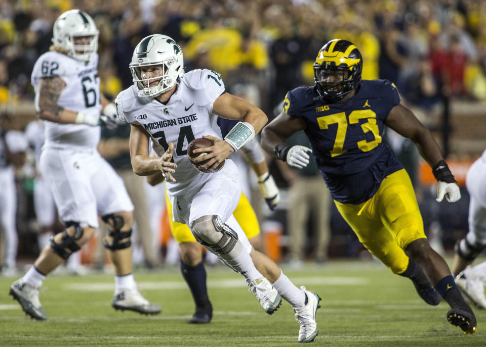 Michigan State quarterback Brian Lewerke (14) rushes ahead of Michigan defensive lineman Maurice Hurst (73) for a touchdown in the first quarter of an NCAA college football game in Ann Arbor, Mich., Saturday, Oct. 7, 2017. (AP Photo/Tony Ding)