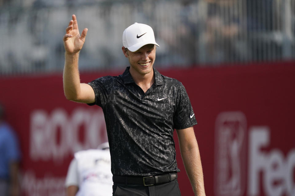 Cam Davis of Australia acknowledges the crowd after scoring an eagle on the 17th green from the sand during the final round of the Rocket Mortgage Classic golf tournament, Sunday, July 4, 2021, at the Detroit Golf Club in Detroit. (AP Photo/Carlos Osorio)