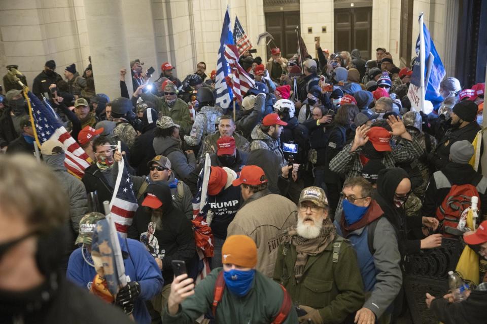 Pro-Trump protesters fill the U.S. Capitol building, many of them wearing military gear.