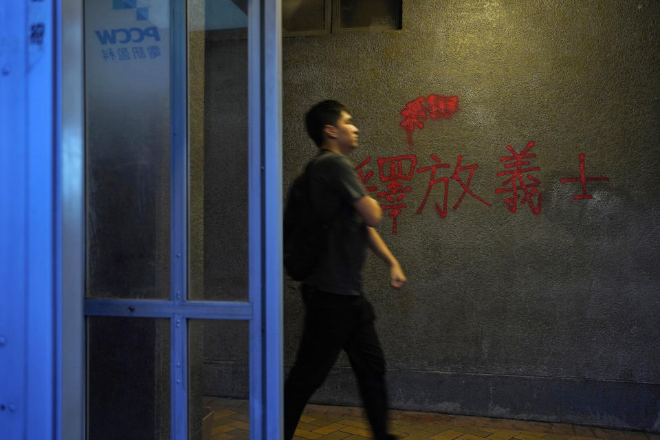 FILE - In this Sept. 17, 2019, file photo, a man walks past a red anti-government graffiti reads in Chinese "Release righteous" outside a subway station in Hong Kong. A year after Beijing imposed a harsh national security law on Hong Kong, the civil liberties that raised hopes for more democracy are fading. (AP Photo/ Vincent Yu, File)