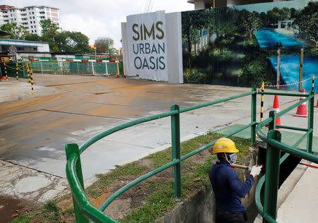 A worker cleans out the drains outside a construction site where locally transmitted Zika cases were first discovered in Singapore August 31, 2016. REUTERS/Edgar Su