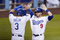 Los Angeles Dodgers' Gavin Lux, right, is congratulated by Chris Taylor after hitting a three-run home run during the eighth inning of an interleague baseball game against the Seattle Mariners Tuesday, May 11, 2021, in Los Angeles. (AP Photo/Mark J. Terrill)