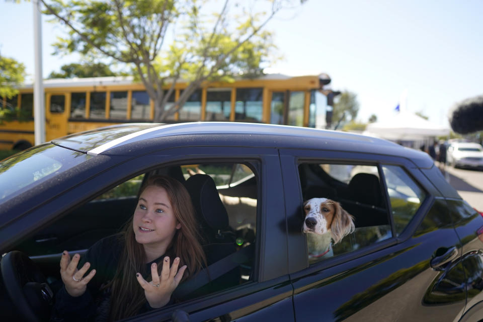 Brooklyn Pittman talks as she sits in her car with her dogs after receiving food from an Armed Services YMCA food distribution, Oct. 28, 2021, in San Diego. As many of 160,000 active duty military members are having trouble feeding their families, according to Feeding America, which coordinates the work of more than 200 food banks around the country. (AP Photo/Gregory Bull)