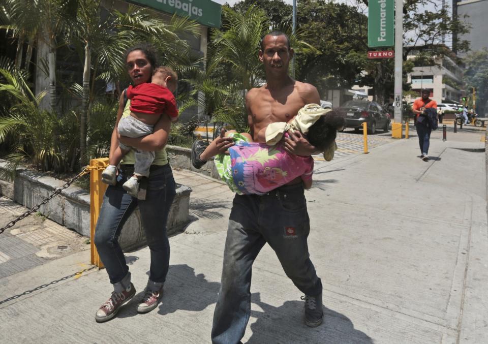 <p>Una familia corre con sus hijos para huir de los efectos del gas lacrimógeno disparado por la Policía Nacional Bolivariana durante una protesta en Caracas, Venezuela, el lunes 10 de abril de 2017. (AP / Fernando Llano)</p>