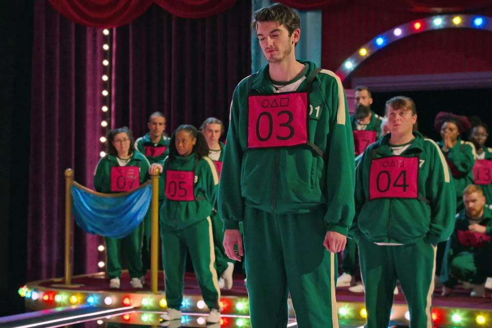 a group of people in green and red clothes on a stage