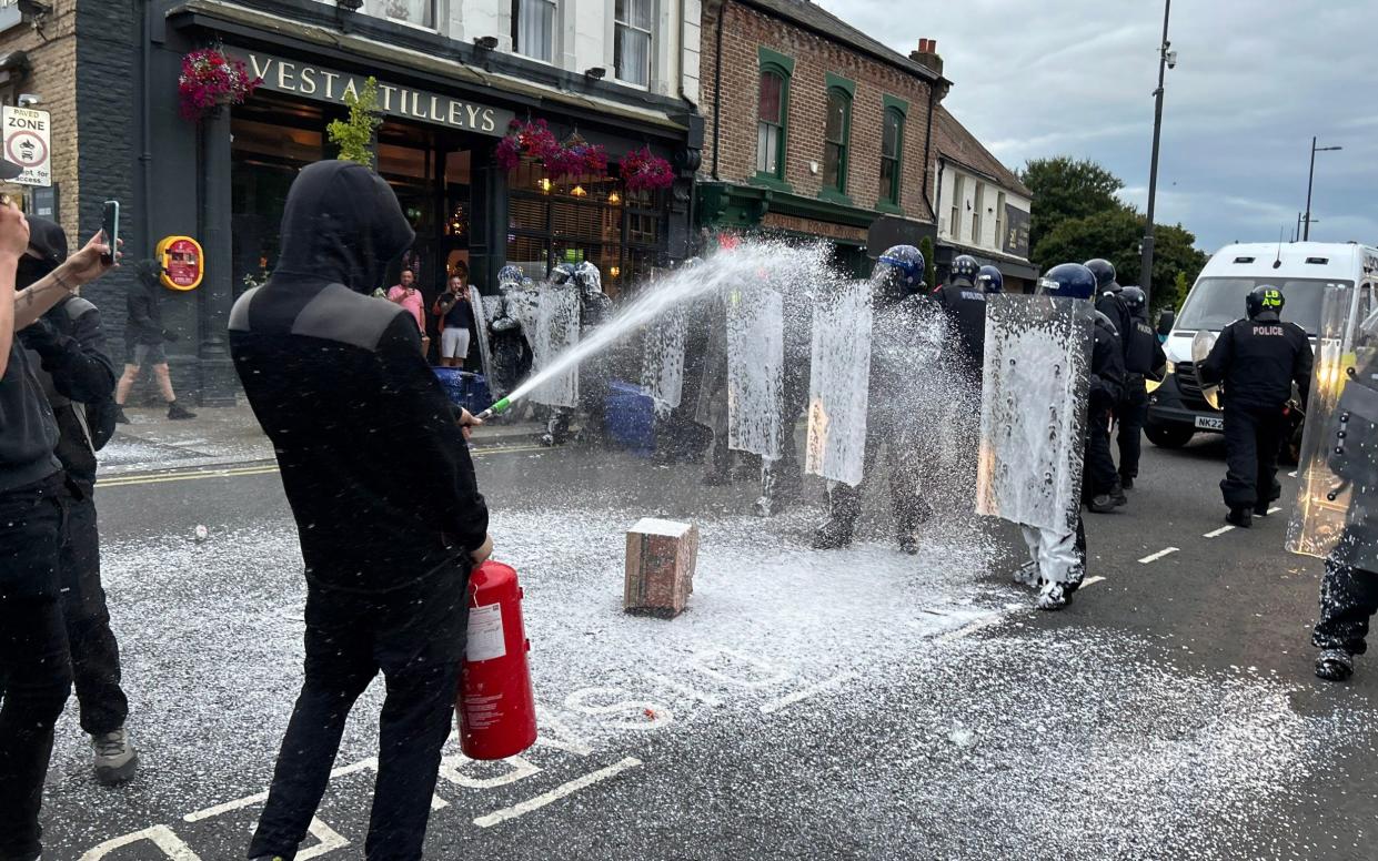 Protesters spray fire extinguishers at riot police officers