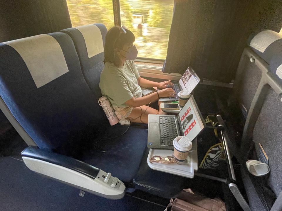 The writer's wife typing on a computer on a train