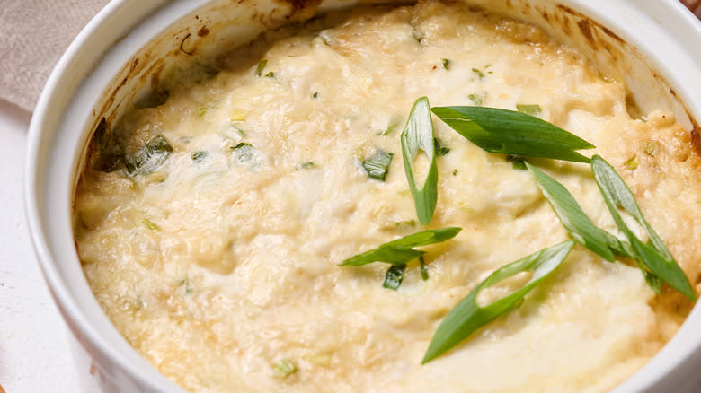 cheese crab dip in round dish with green onion