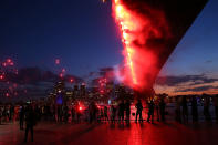 People watch fireworks under The Sydney Harbour Bridge during New Years Eve celebrations on Sydney Harbour on December 31, 2012 in Sydney, Australia. (Brendon Thorne/Getty Images)