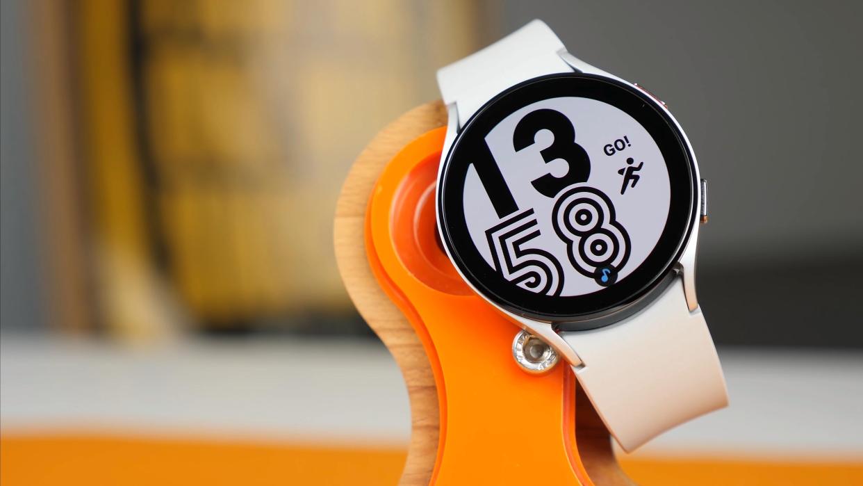  A Samsung Galaxy Watch 4 showing a digital clock and a running figure yelling GO!. 