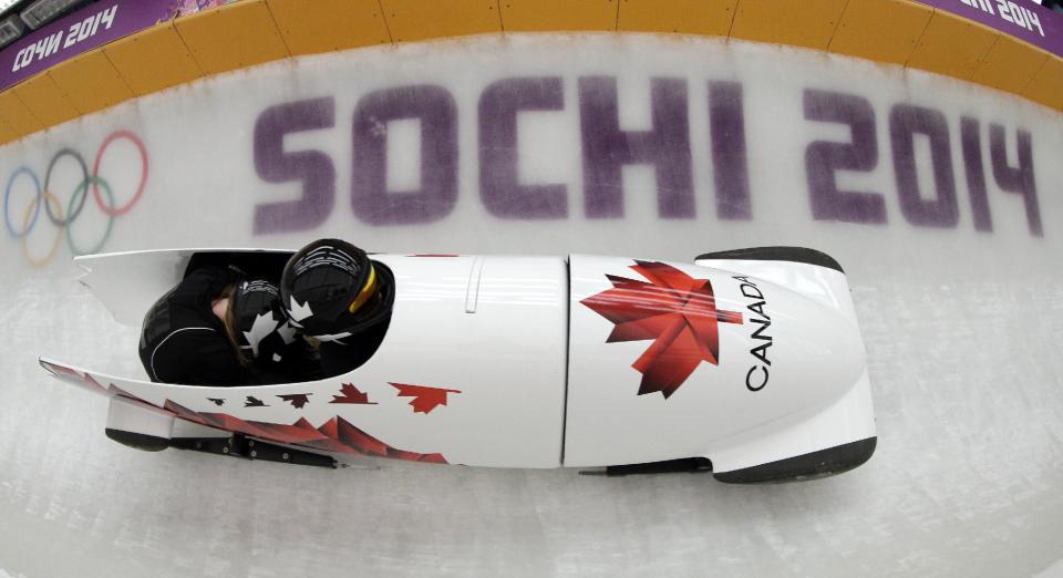 Kaillie Humphries and Heather Moyse of Canada take a turn during a training session for the women's bobsleigh at the 2014 Winter Olympics, Sunday, Feb. 16, 2014, in Krasnaya Polyana, Russia. (AP Photo/Michael Sohn)