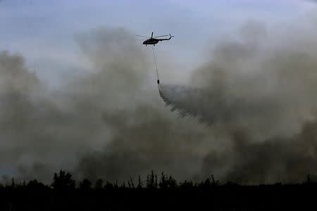 A helicopter from the Indonesian National Disaster Management agency (BNPB) drops water on a fire in Ogan Ilir, near Palembang, South Sumatra, Indonesia, August 11, 2016 in this photo taken by Antara Foto. Antara Foto/Nova Wahyudi/File Photo via REUTERS