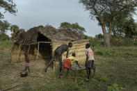 Nine-year-old Akech is helped by her older brothers settling in the new shelter they built in Langic, Northern Bahr el Ghazal State, South Sudan, Wednesday, Oct. 20, 2021. The United Nations says the flooding has affected almost a half-million people across South Sudan since May. (AP Photo/Adrienne Surprenant)