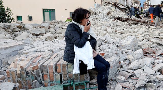 A woman sits along the road following a quake in Amatrice, central Italy, August 24, 2016. Photo: Reuters/Remo Casilli