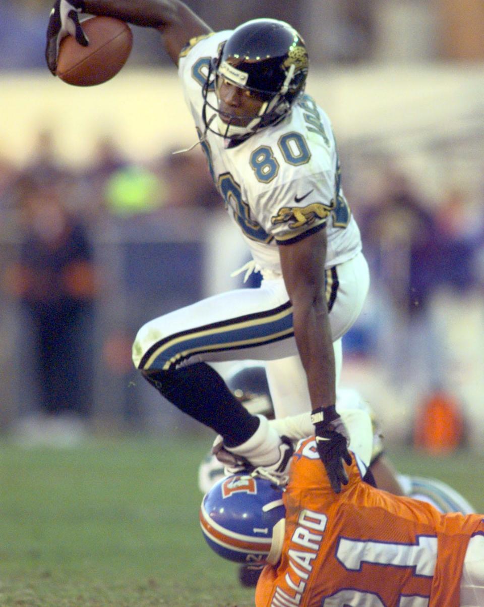 Jacksonville Jaguars wide receiver Willie Jackson (80) gains yardage as Denver Broncos cornerback Randy Hilliard (21) attempts to tackle during an AFC divisional playoff game at Mile High Stadium on January 4, 1997. [Rick Wilson/Florida Times-Union]