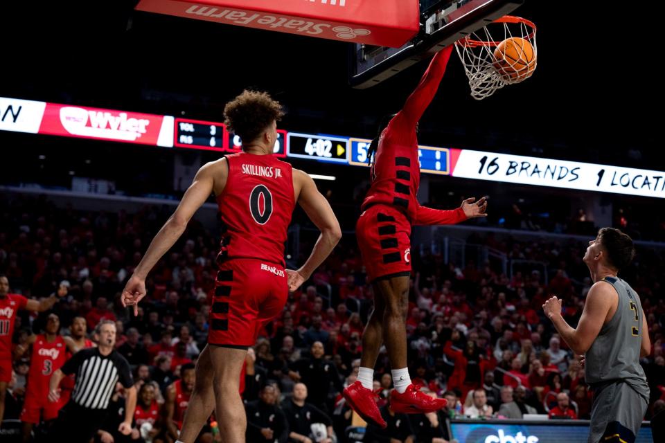 Day Day Thomas, a 6-foot guard, throws down a dunk against West Virginia in UC's 92-56 victory Saturday.