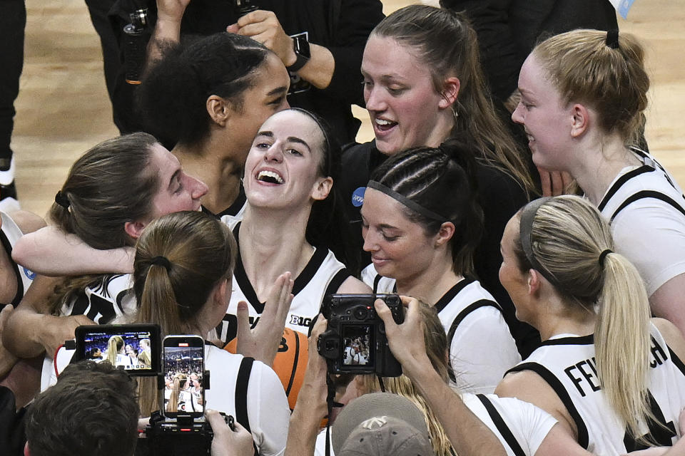 Iowa guard Caitlin Clark, center, celebrates with teammates after Iowa defeated LSU in an Elite Eight round college basketball game during the NCAA Tournament, Monday, April 1, 2024, in Albany, N.Y. (AP Photo/Hans Pennink)