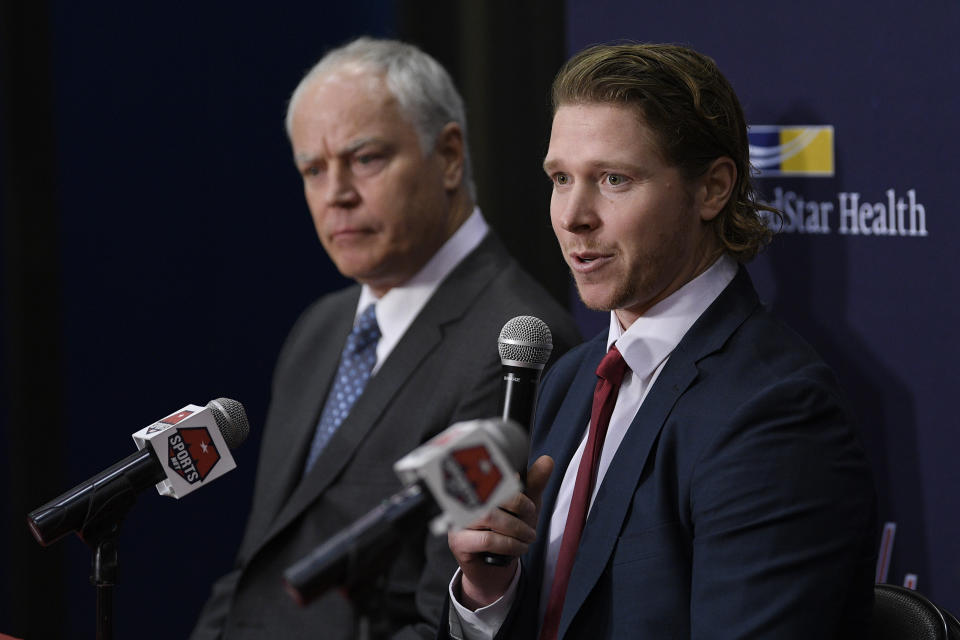 Washington Capitals center Nicklas Backstrom, right, of Sweden, speaks during an NHL hockey news conference about the Capitals re-signing him to a five-year contract, Tuesday, Jan. 14, 2020, in Washington. At left is Capitals general manager Brian MacLellan. (AP Photo/Nick Wass)