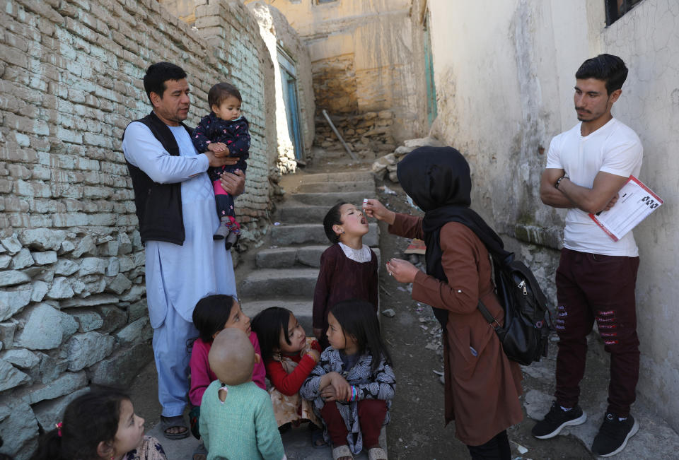 FILE - Shabana Maani, gives a polio vaccination to a child in the old part of Kabul, Afghanistan, March 29, 2021. The Taliban-run Afghan public health ministry announced Sunday, Nov. 7, 2021, the start of a four-day nationwide polio vaccination campaign aimed at inoculating children under age 5. (AP Photo/Rahmat Gul, File)