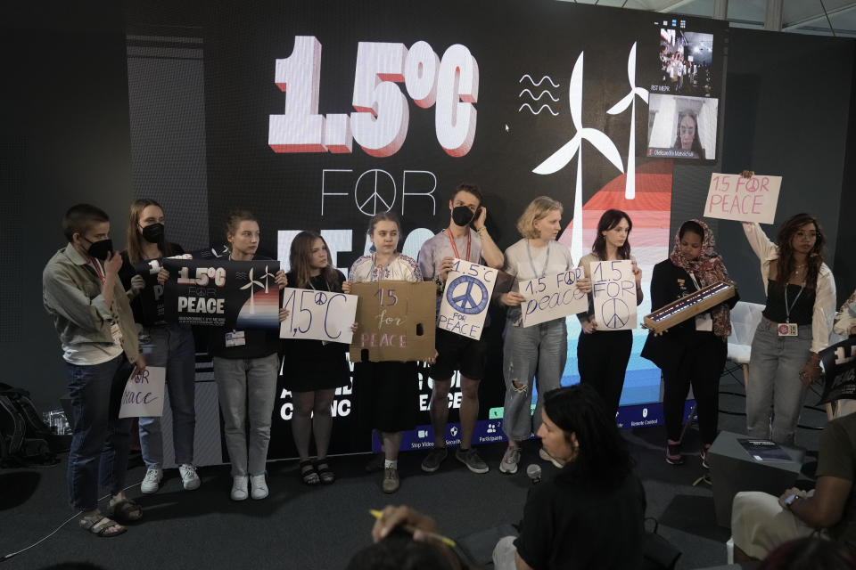 Activists hold signs for 1.5 degrees Celsius for Peace during a session at the COP27 U.N. Climate Summit, Thursday, Nov. 17, 2022, in Sharm el-Sheikh, Egypt. (AP Photo/Nariman El-Mofty)