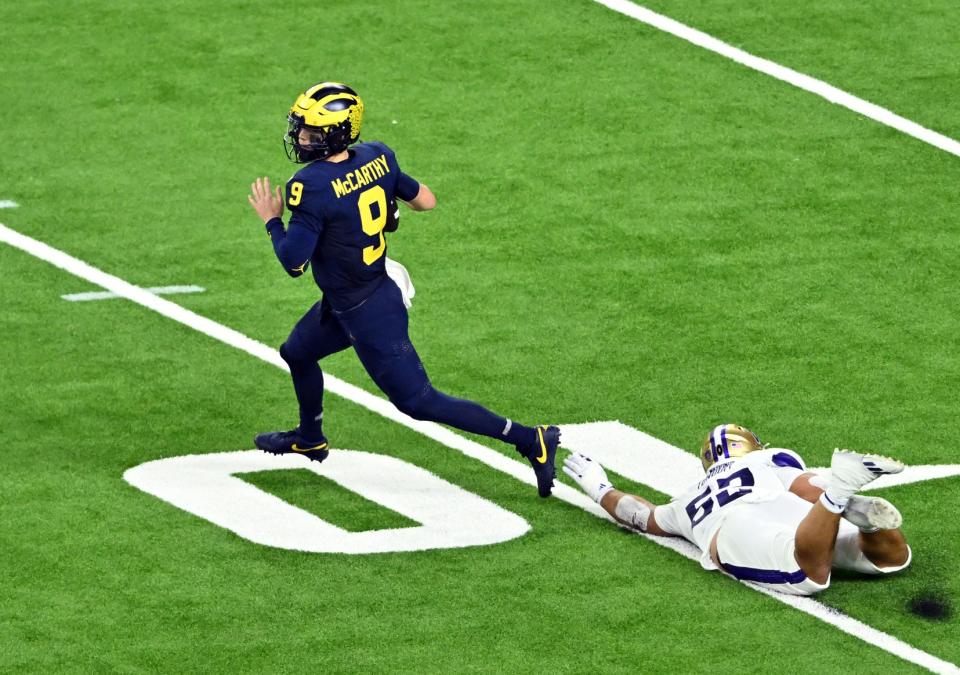 Jan 8, 2024; Houston, TX, USA; Michigan Wolverines quarterback J.J. McCarthy (9) escapes a tackle by Washington Huskies defensive end Voi Tunuufi (52) during the fourth quarter in the 2024 College Football Playoff national championship game at NRG Stadium. Mandatory Credit: Maria Lysaker-USA TODAY Sports